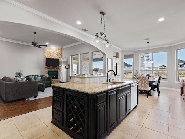 kitchen featuring a kitchen island with sink, sink, hanging light fixtures, and light tile patterned floors