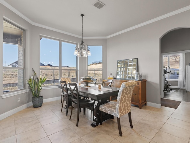 tiled dining room featuring a notable chandelier and ornamental molding