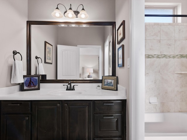 bathroom with tiled shower / bath combo and vanity