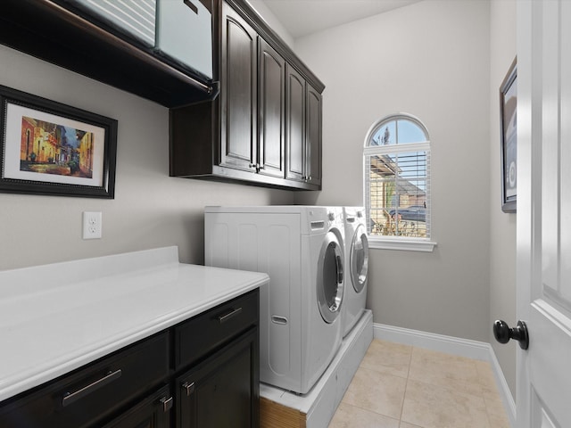 laundry area featuring light tile patterned flooring, cabinets, and washer and dryer