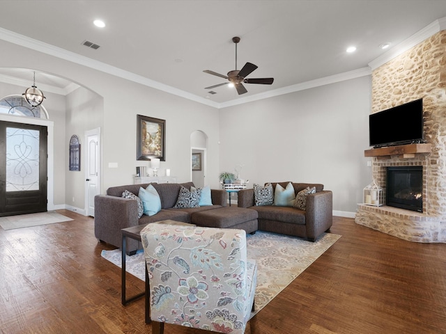 living room featuring ornamental molding, hardwood / wood-style floors, ceiling fan, and a fireplace