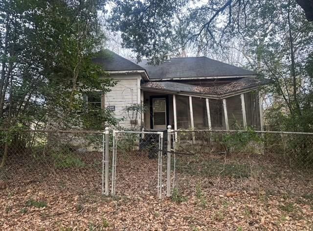 rear view of property featuring a sunroom