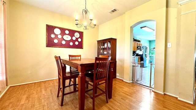 dining area featuring light hardwood / wood-style floors and an inviting chandelier