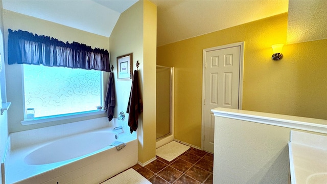 bathroom featuring independent shower and bath, tile patterned flooring, and lofted ceiling