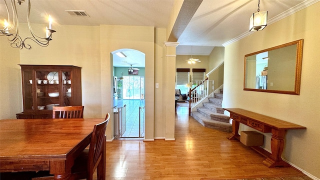 interior space featuring ceiling fan, hardwood / wood-style floors, ornamental molding, and ornate columns