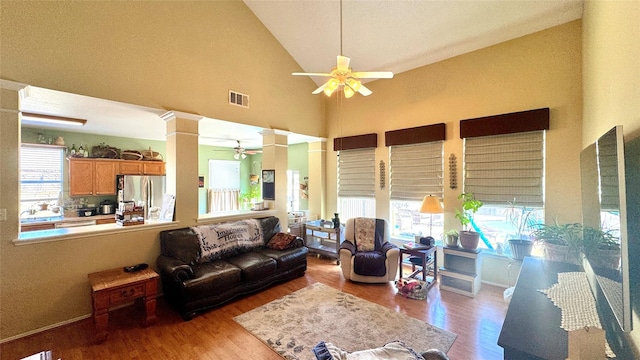 living room with ceiling fan, light hardwood / wood-style flooring, ornate columns, and plenty of natural light