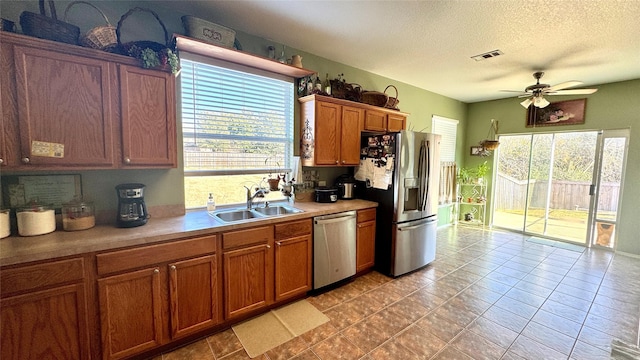 kitchen featuring sink, plenty of natural light, a textured ceiling, and appliances with stainless steel finishes