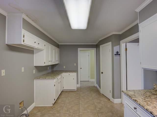 kitchen with white cabinetry, light tile patterned floors, and crown molding