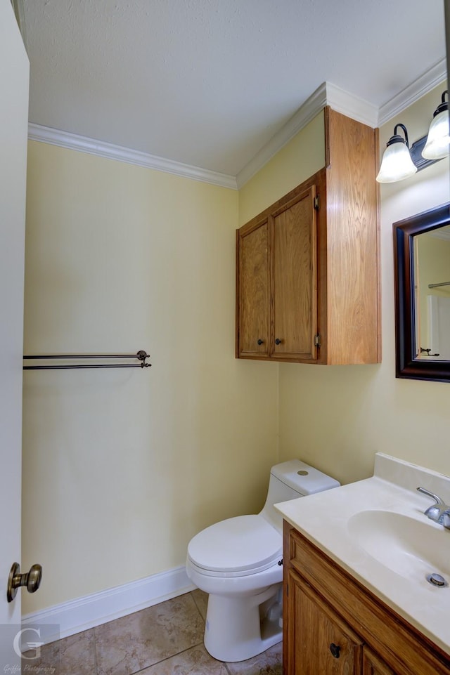 bathroom featuring vanity, toilet, crown molding, and tile patterned flooring