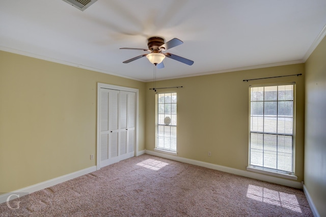 carpeted empty room featuring ceiling fan and crown molding