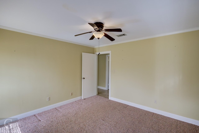 carpeted spare room with ceiling fan and ornamental molding