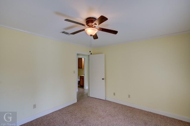 carpeted spare room featuring ceiling fan and ornamental molding