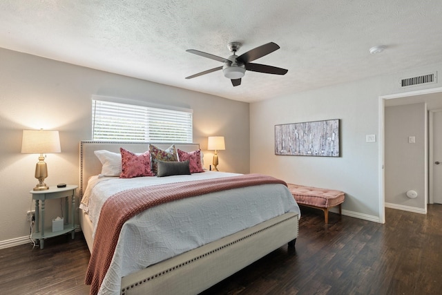 bedroom featuring ceiling fan, dark wood-type flooring, and a textured ceiling