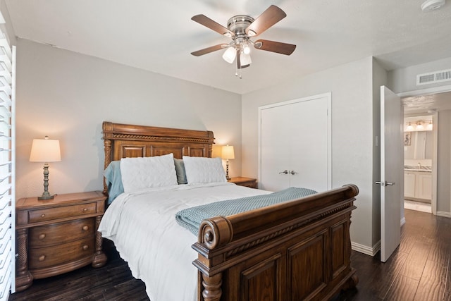 bedroom featuring ceiling fan, dark hardwood / wood-style floors, a closet, and ensuite bath