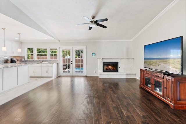 unfurnished living room featuring sink, french doors, ornamental molding, dark hardwood / wood-style floors, and lofted ceiling