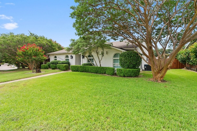 view of front of property featuring cooling unit and a front lawn