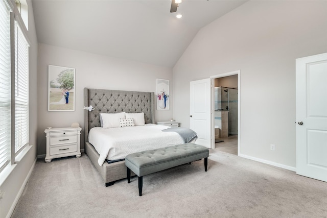 carpeted bedroom with ceiling fan, high vaulted ceiling, and ensuite bath