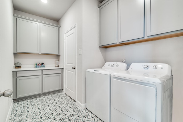 laundry area featuring washing machine and dryer and cabinets