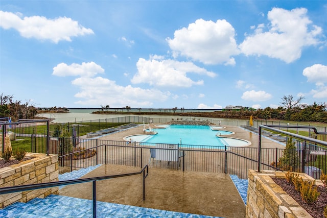 view of pool featuring a patio and a water view