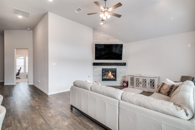 living room with dark hardwood / wood-style flooring, ceiling fan, lofted ceiling, and a fireplace