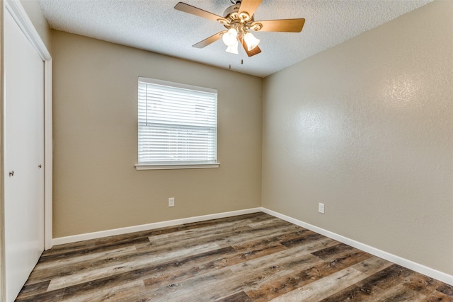 spare room with ceiling fan, dark hardwood / wood-style floors, and a textured ceiling