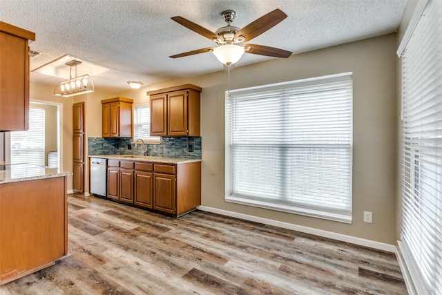 kitchen featuring decorative light fixtures, dishwasher, decorative backsplash, ceiling fan, and light wood-type flooring