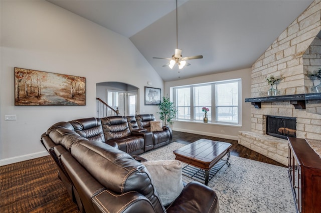 living room featuring ceiling fan, wood-type flooring, vaulted ceiling, and a fireplace