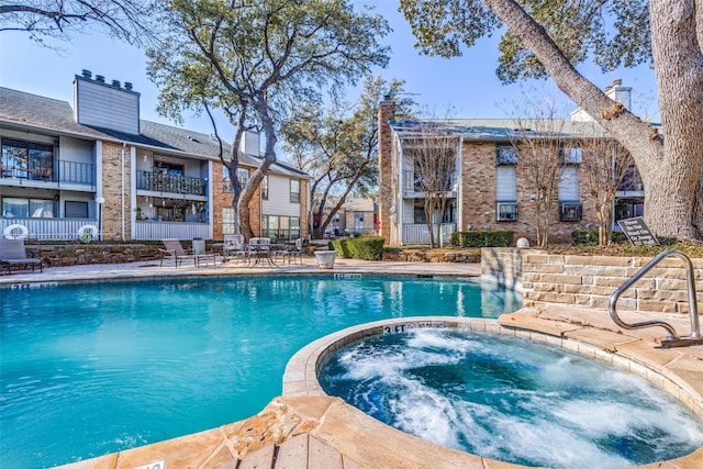 community pool with fence and a community hot tub