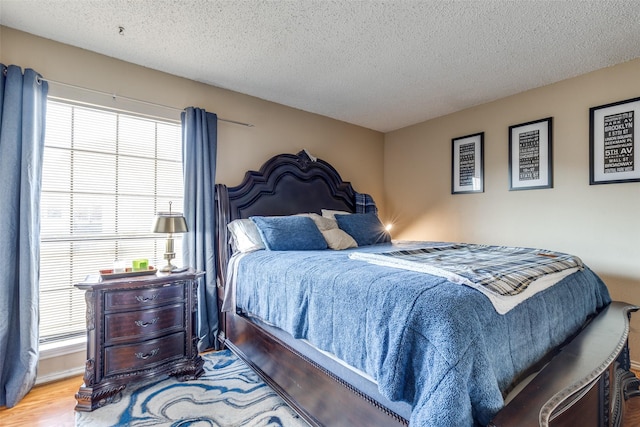 bedroom featuring a textured ceiling and wood finished floors