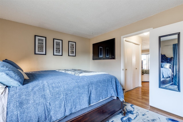 bedroom with a textured ceiling and wood finished floors