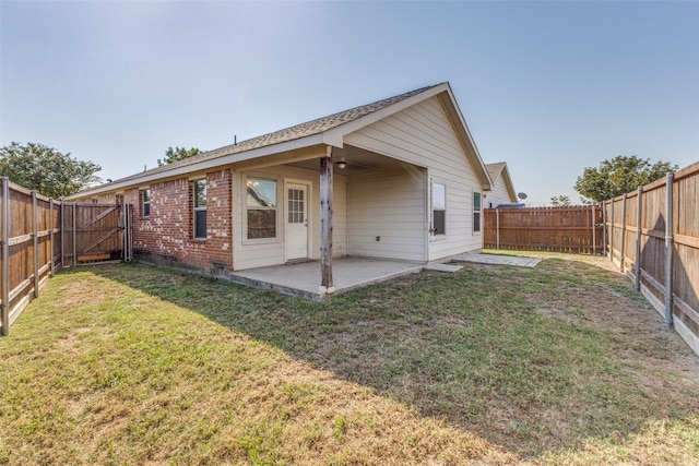 back of house with a lawn and a patio area