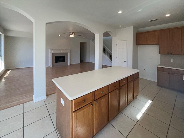 kitchen with ceiling fan, a kitchen island, and light tile patterned floors