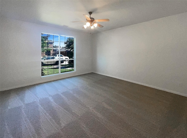 spare room featuring ceiling fan and carpet