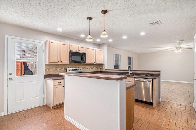 kitchen featuring a textured ceiling, appliances with stainless steel finishes, decorative light fixtures, tasteful backsplash, and sink