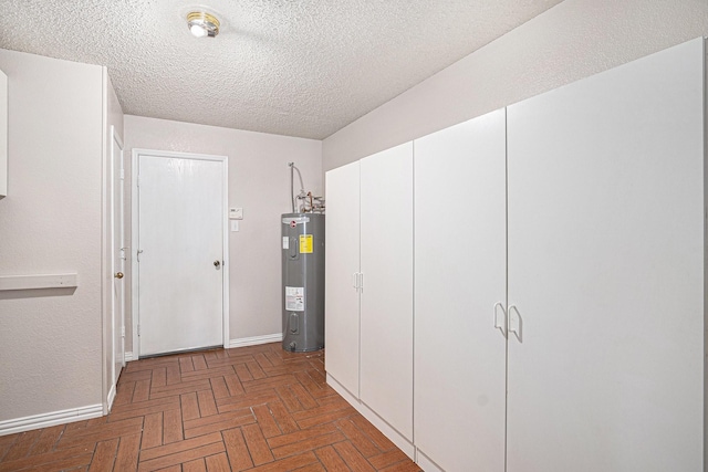 corridor with a textured ceiling and water heater