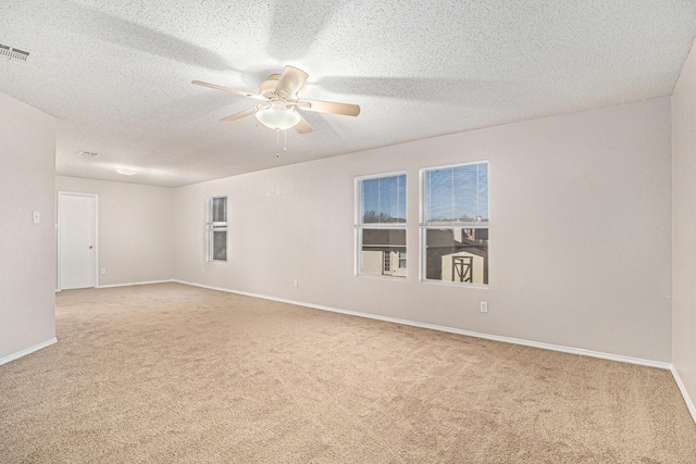 empty room with light carpet, a textured ceiling, and ceiling fan