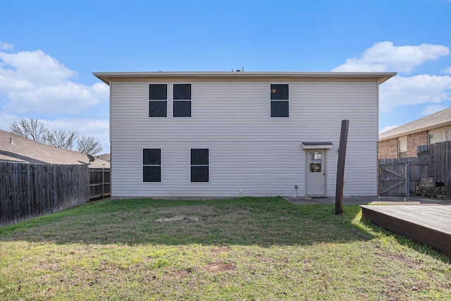 rear view of property with a deck and a lawn