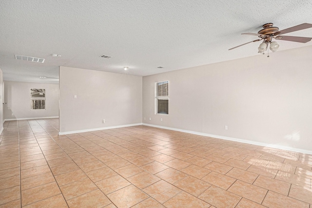 tiled spare room with ceiling fan and a textured ceiling