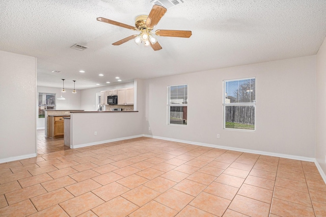 unfurnished living room with ceiling fan, light tile patterned floors, and a textured ceiling