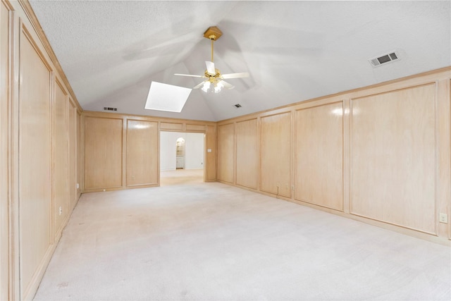 bonus room with ceiling fan, light colored carpet, and lofted ceiling with skylight