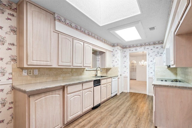 kitchen featuring sink, backsplash, white appliances, and light brown cabinetry