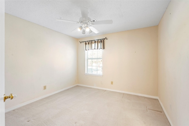 empty room with a textured ceiling, light colored carpet, and ceiling fan