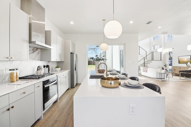 kitchen featuring hanging light fixtures, sink, tasteful backsplash, a kitchen island, and stainless steel appliances