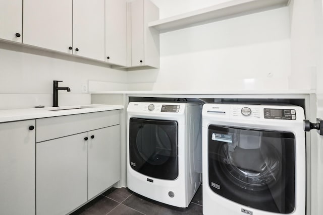 laundry room featuring cabinets, dark tile patterned floors, sink, and independent washer and dryer