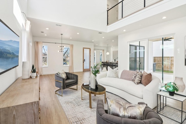 living room featuring light wood-type flooring and a chandelier