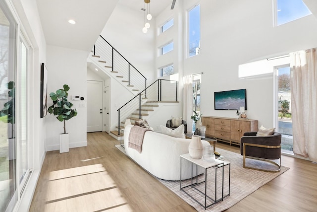 living room featuring a high ceiling and light wood-type flooring