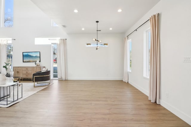 entrance foyer with light hardwood / wood-style floors, a notable chandelier, and plenty of natural light