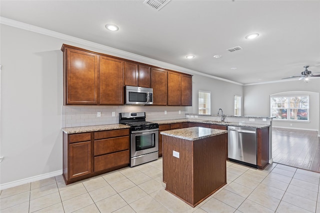 kitchen featuring stainless steel appliances, a peninsula, visible vents, and light stone countertops