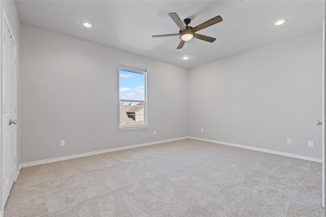 empty room featuring a ceiling fan, recessed lighting, light colored carpet, and baseboards