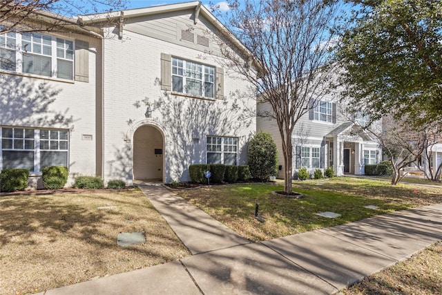 view of front of property with brick siding and a front yard